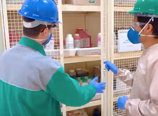 Trabalhadores fechando um armário com produtos