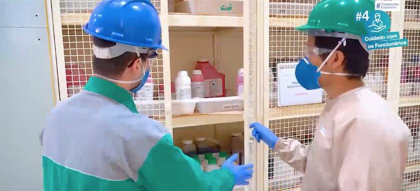 Trabalhadores fechando um armário com produtos