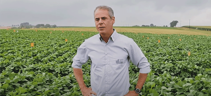 Sênio Prestes em frente a uma plantação de soja