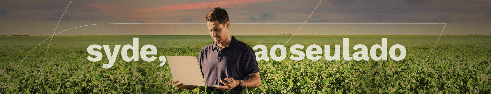 homem segurando notebook no meio do campo